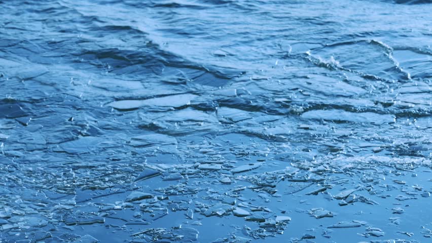 Broken Ice Floating on Cold Blue Water Surface