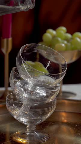Sparkling Wine Being Poured into Stacked Vintage Coupe Glasses. Vertical video