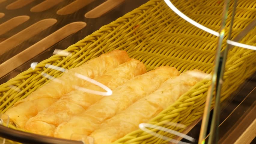 Fresh croissants in wicker basket at bakery shop