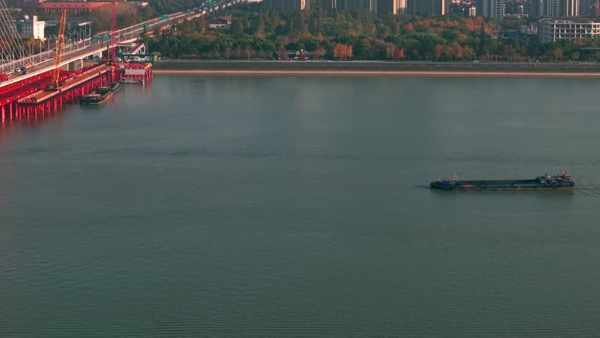 Barge travels on the river at daytime in China, carrying cargo