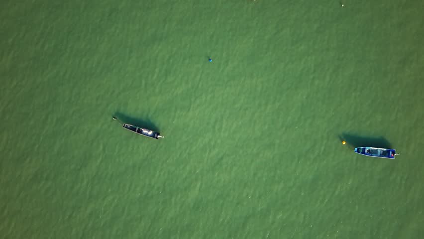 Aerial view of several fishing boats anchored in calm, green water in Hangzhou, China during daytime