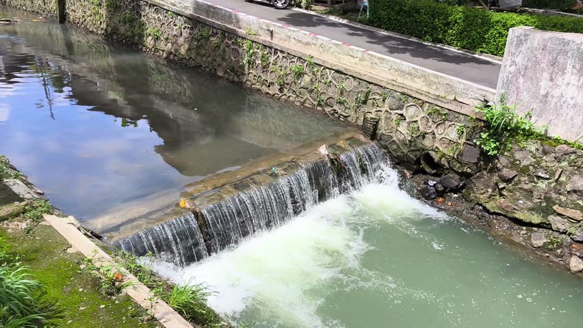 A small waterfall in a river on the outskirts of town