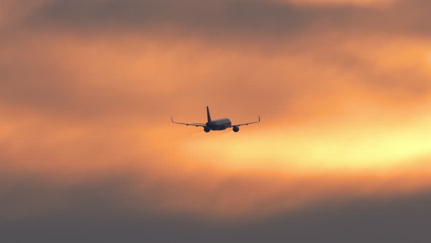 Jet aircraft climbing after takeoff against a vibrant sunset sky. Perfect for concepts of aviation, travel, and atmospheric flight moments