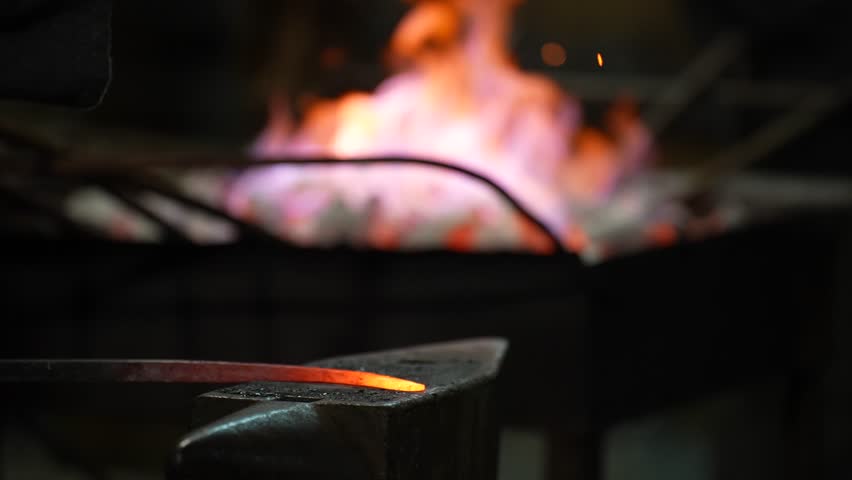 Hot Iron and Hammer on Anvil in Old Traditional Forge, Metal Takes Shape