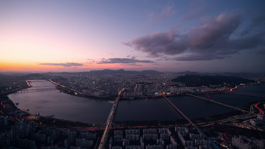 Epic dusk to night timelapse of Seoul skyline from Lotte World Tower overlooking Han River bridges and glowing city lights in South Korea