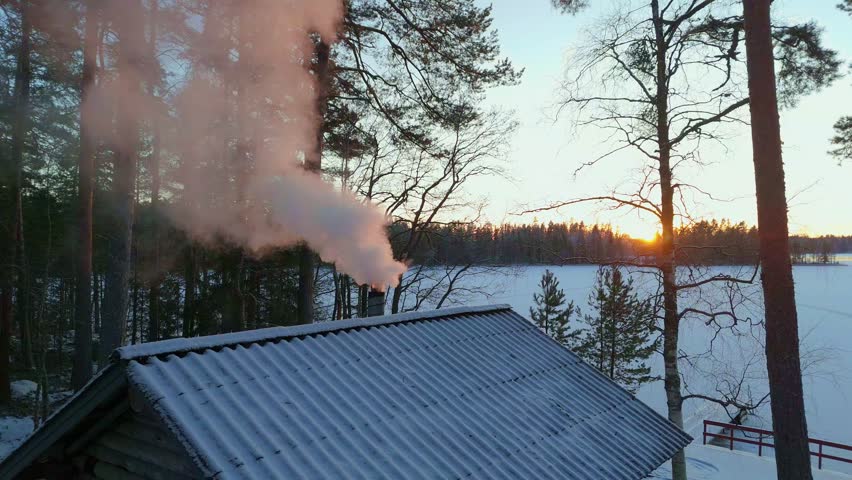 Thick Smoke Billowing from Cabin Chimney during Vibrant Winter Sunset, Traditional Finnish Sauna on a Frozen Lake, Cozy Nordic Lifestyle
