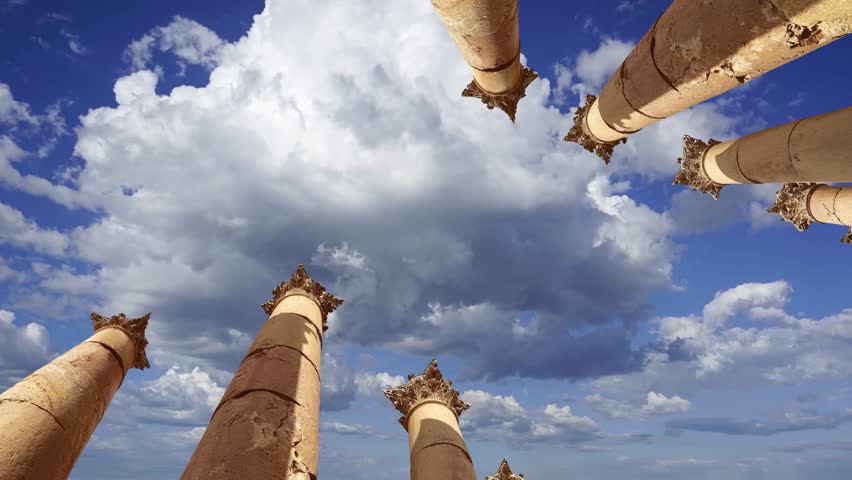 Roman Columns in the Jordanian city of Jerash (Gerasa of Antiquity), capital and largest city of Jerash Governorate, Jordan. Against the background of a beautiful sky with clouds. 4K, time lapse  