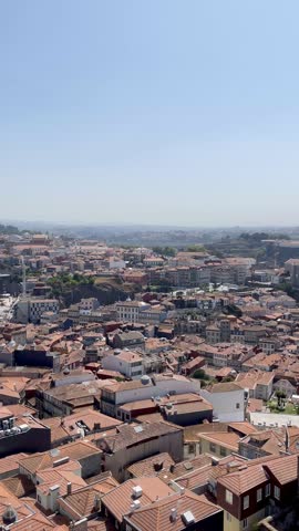 Panoramic aerial view of Porto old town with red tile roofs and the Douro River under a clear blue sky. Beautiful urban landscape in Portugal