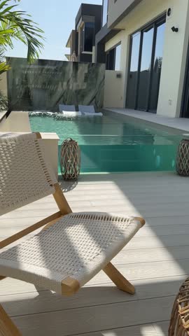Small swimming pool with canopy and sofa in the backyard of a private villa in Dubai on a sunny day