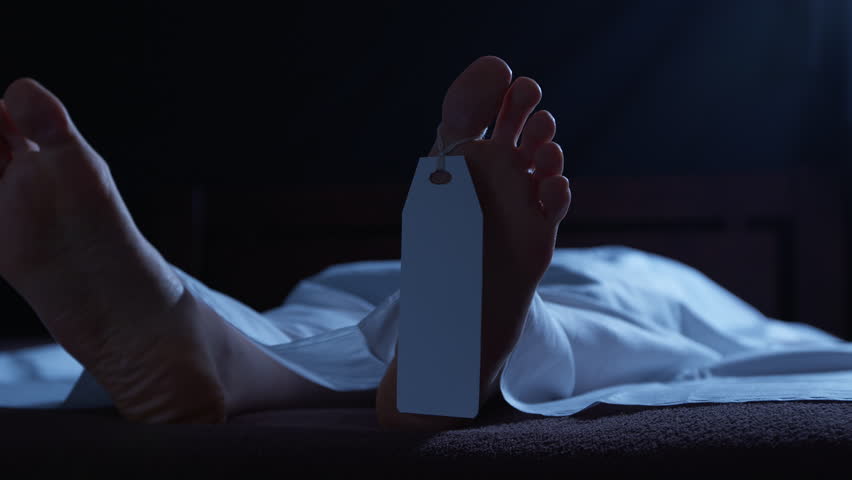 A human corpse lying in a morgue, covered with a white sheet and a tag on its leg. Concept of a dead person, a deceased person.