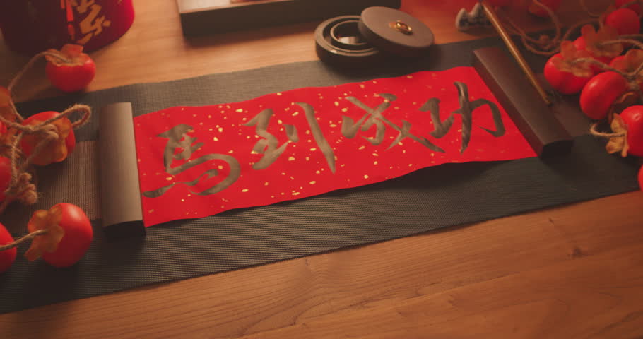 Writing the character "福" (fortune) and wishing for "马到成功" (success upon arrival) during Chinese New Yea.Chinese texts are "马到成功“