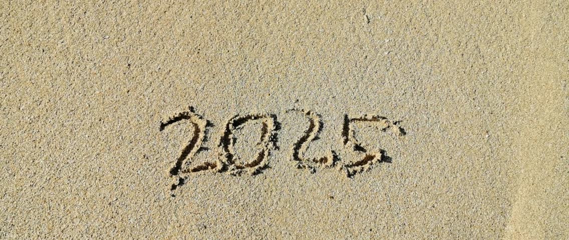 The number 2025 writen on the white sand of the beach is erased by the waves. It symbolizes the year 2025 has ended. 