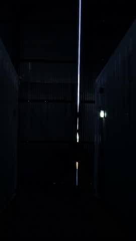Industrial Interior With Silhouette of Man Opening Doors to Daylight - Vertical 4K
