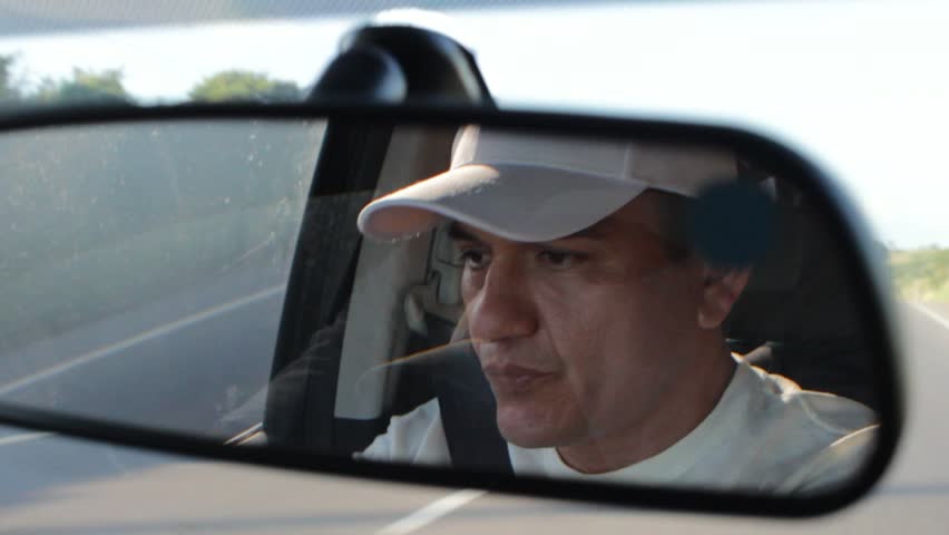 View of a Hispanic man wearing a cap driving a car on a sightseeing trip in Neiva, Huila, southern Colombia. Concept of lifestyle and transportation 