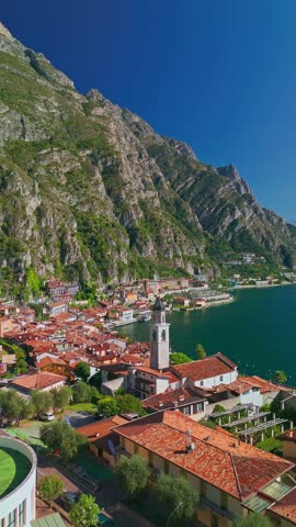 Aerial view of picturesque Limone sul Garda on Lake Garda with summer landscape, alpine shoreline, mountains, ferry boat and scenic travel setting in Northern Italy.