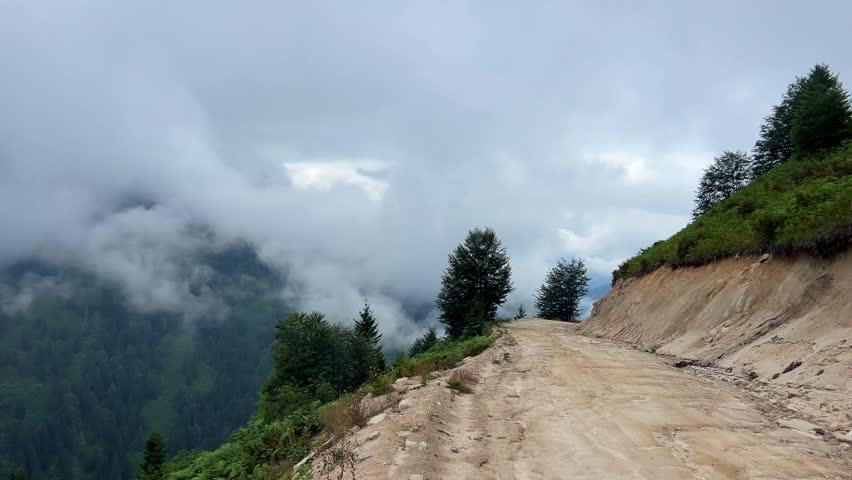 The plateau is covered with clouds that move over the mountain valley. The movement of the fog creeping over the hills at dawn. Mountains and fog on the Pokut plateau in the highlands of the Black Sea