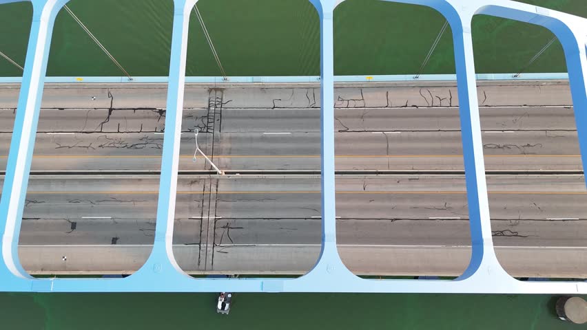 Birdseye Drone shot of Leo Frigo Bridge in Green Bay Wisconsin USA at Dusk.  Evening Light reflects off the Fox River with Traffic passing on the nearby bridge.  Dramatic Right to Left shot over the highway.  