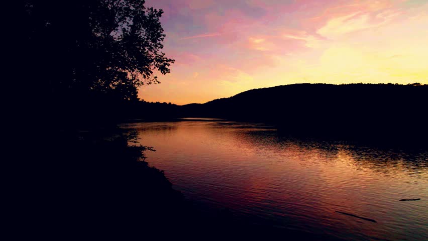 Drone shot of dramatic red sunset reflecting on river