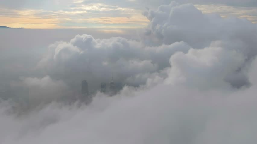 A lone skyscraper pierces through the clouds, its spire rising above the mist—where architecture meets the atmosphere in a surreal dance of steel and sky