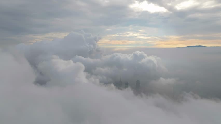 A lone skyscraper pierces through the clouds, its spire rising above the mist—where architecture meets the atmosphere in a surreal dance of steel and sky
