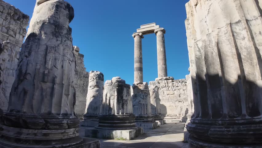 Interior view of the ancient Temple of Apollo in Didyma, Turkey, featuring massive stone columns under a clear blue sky.