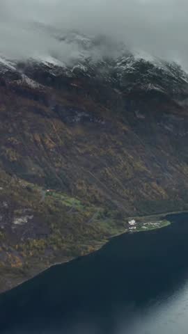 Aerial view of norwegian fjord landscape with snow capped mountain peaks and autumn foliage