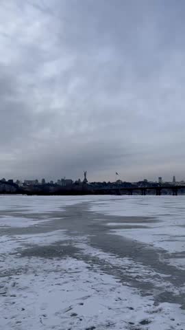 Video of frozen Dnipro River with zoom on Motherland Monument and Kyiv-Pechersk Lavra