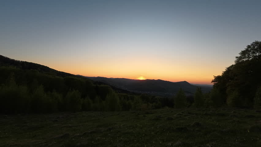 Majestic epic warm sky over beautiful tops of hills. Dramatic sunset moment. Landscape scenery of amazing dusk sunset in mountains at spring time