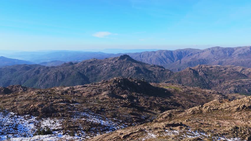 Hiker Man Standing on Granite Rocks and Mountains of Peneda-Geres National Park on Sunny Winter Day. Portugal. Aerial View. Moving Backwards