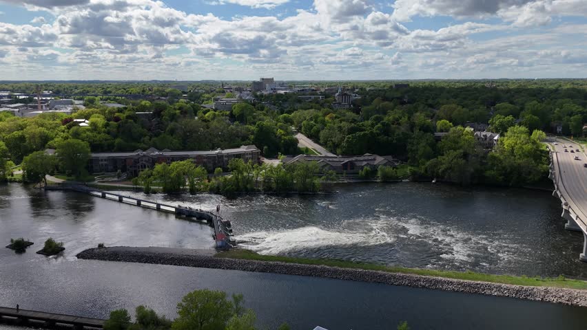 Hyper lapse Appleton Wisconsin USA Drone Long Push Shot Towards Dam.  Low approaching Fox River.  Blue Skies, Clouds on the Horizon.  Rapids and rushing water in the distance.  Eventually gets close to downtown Appleton and campus.