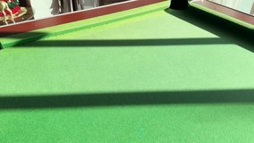 A yellow pool ball rolls across green felt under bright sunlight with long dramatic shadows - Powered by Shutterstock - Get 15% off with code: PIKWIZARD15