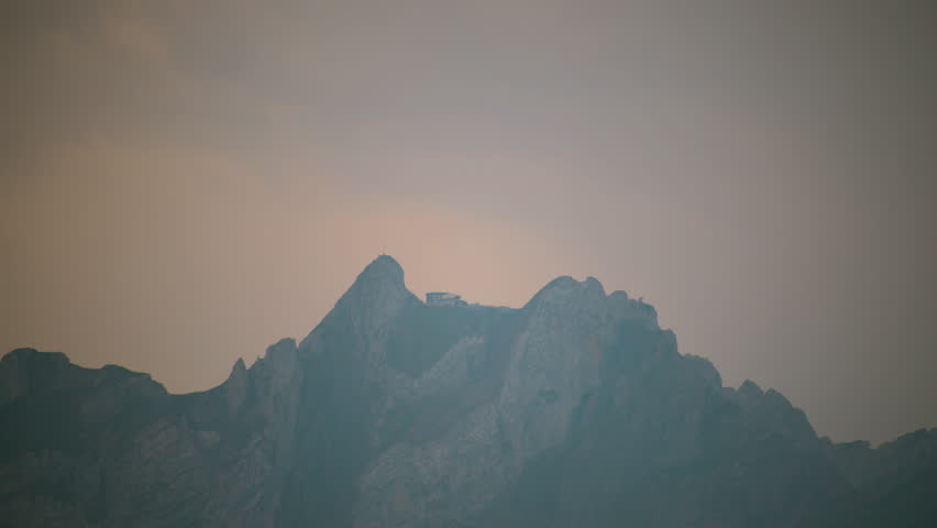 Mountain peak near Lucerne partially covered by clouds creating a dramatic alpine landscape.