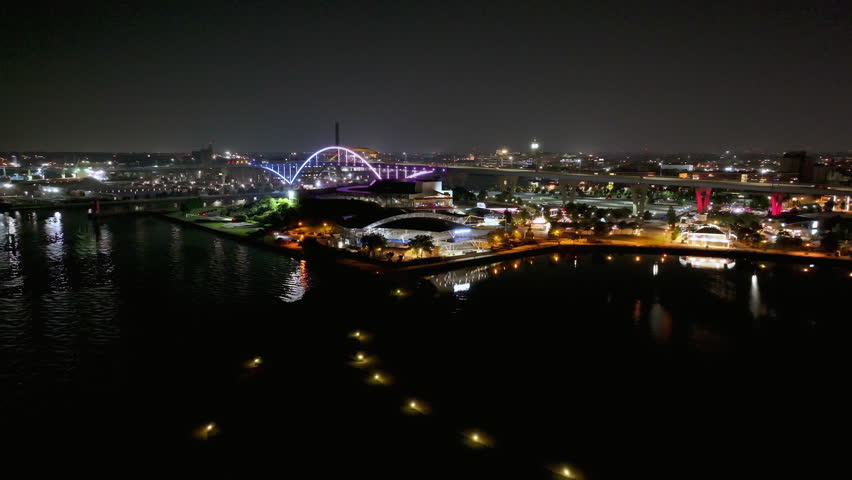 Drone following the illuminated coastline to the Hoan bridge, night in Milwaukee