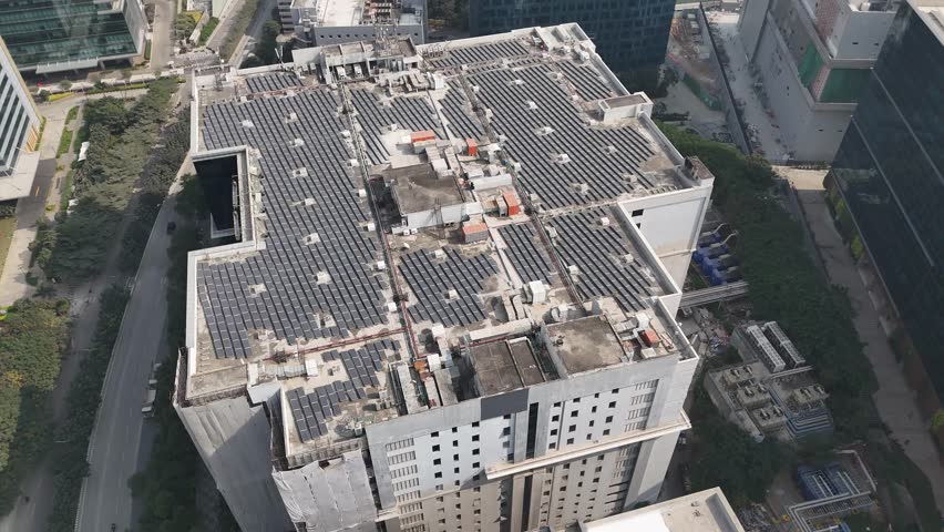 Bird’s-eye drone shot of a metropolitan neighborhood bulding filled with solar panels that produce solar energy