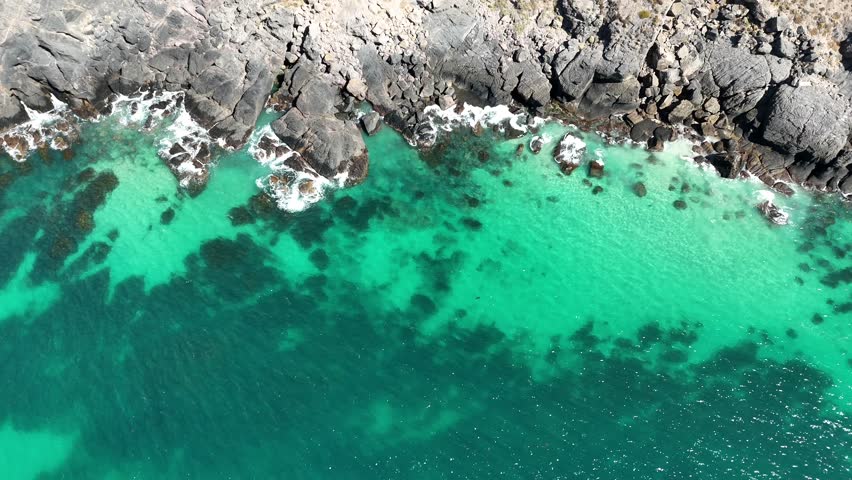 Phu Quoc Island, An Giang, Vietnam – 4K Aerial Drone View of Tropical Beaches, Turquoise Water, Sandy Shoreline, Rocky Coast, Coral Reefs and Lush Coastal Forest. 
Phu Quoc Island, An Giang Province, Vietnam viewed from an elevated aerial perspective, showcasing clear turquoise waters meeting sandy beaches, rocky shorelines, and shallow reef areas along the tropical coast. The scene highlights gentle waves, underwater textures, and vibrant colour gradients created by sunlight over calm coastal waters.
Natural contrasts between white sand, emerald-green sea, dark rock formations, and dense coastal vegetation emphasise the island’s unspoilt character. The expansive viewpoint captures the tranquil atmosphere of Vietnam’s largest island, blending tropical marine environments with untouched shoreline landscapes.
Ideal for projects focused on tropical destinations, island landscapes, beach and ocean scenery, travel and tourism, nature and environment, coastal ecosystems, relaxation themes, and cinematic natural backgrounds.
