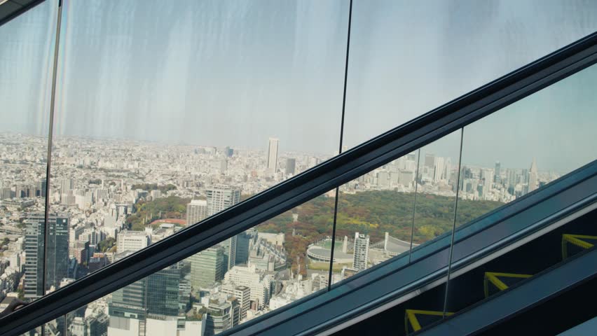 Woman ascending escalator admiring tokyo cityscape view