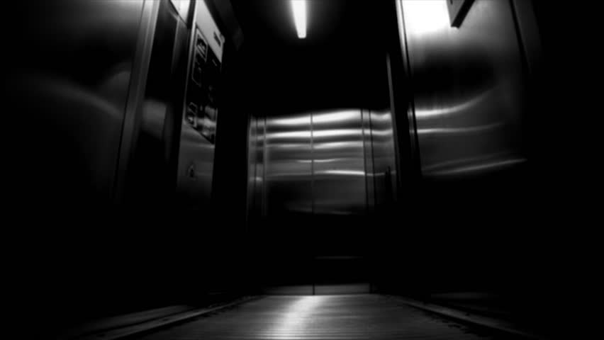 Elevator interior with doors open, revealing a dimly lit space with stairs in the background.