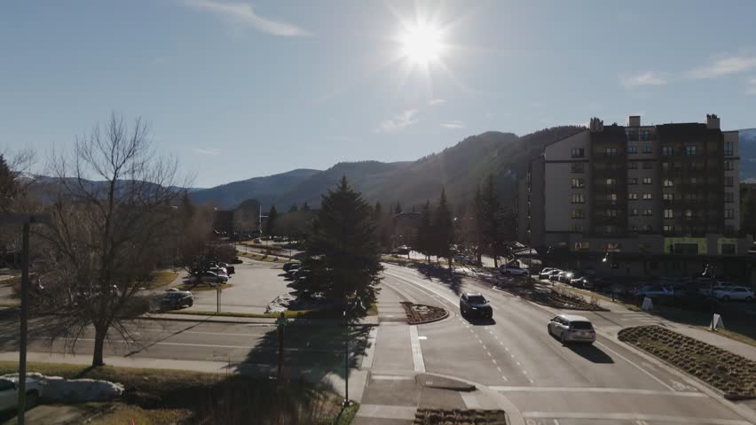 Aerial drone upward reveal over Avon, Colorado showing the mountain town transitioning into sky and surrounding peaks. Cinematic establishing shot for travel, documentary, environmental storytelling.