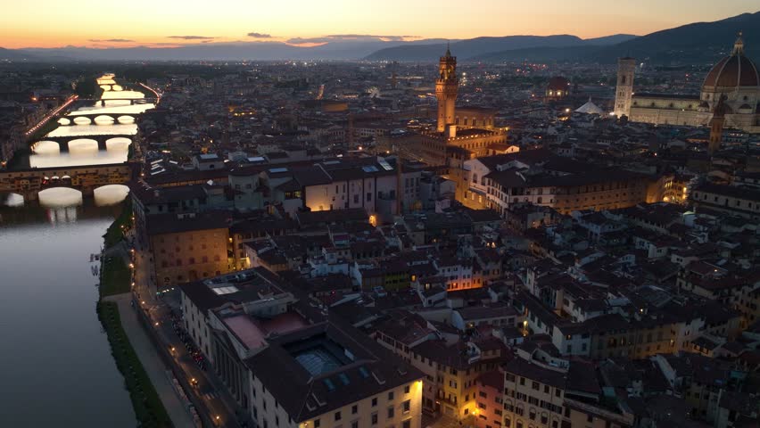aerial night view of Florence city with Arno river, Ponte Vecchio and Florence Cathedral, illuminated Florence evening view, tourism in Italian Tuscany