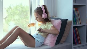 A little girl is using a tablet and headphones. The kid is playing virtual games or watching cartoons on her smartphone. The child with a smartphone. The problem of addiction to gadgets - Powered by Shutterstock - Get 15% off with code: PIKWIZARD15