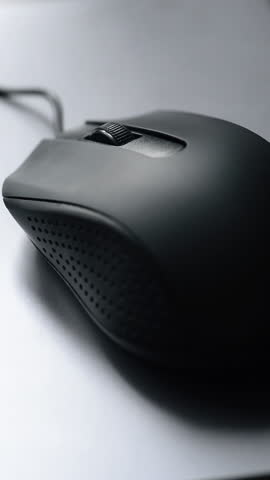 Focusing on a hand using a black computer mouse. The interaction suggests computer use, gaming, or web browsing. Vertical video