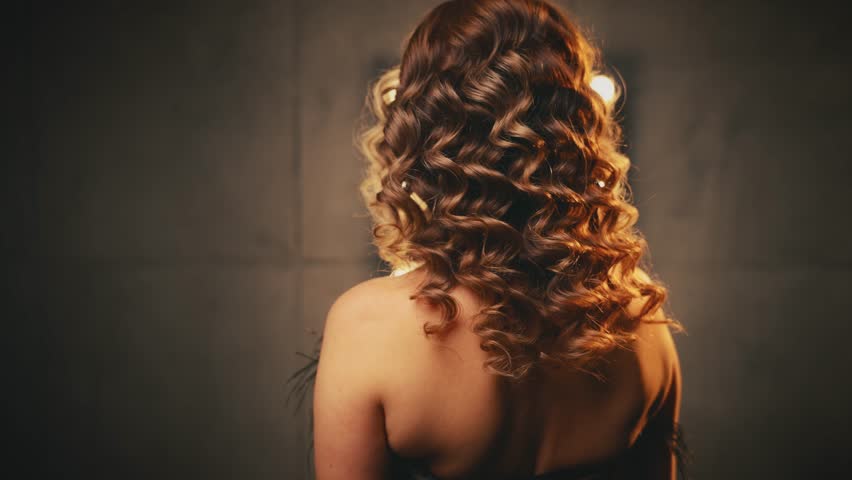 Happy woman rear view looking back, blonde hair flying in motion. retro lady wave curly hairstyle. Portrait flapper adult girl sexy eyes face sparkly shiny dress black ostrich feathers. 20s old style.