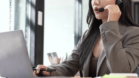Professional customer service woman wearing a headset typing on a laptop while talking to a client in a modern office call center environment. - Powered by Shutterstock - Get 15% off with code: PIKWIZARD15