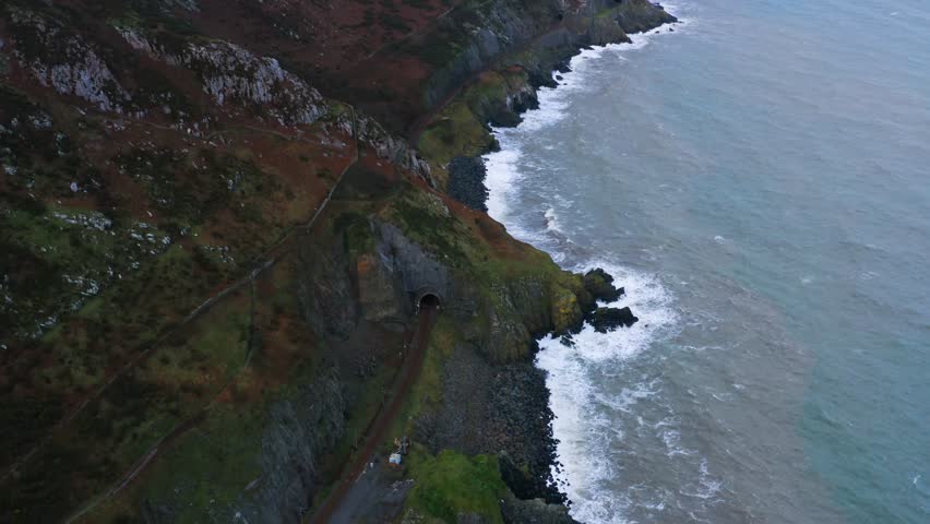 Aerial View of the Bray Head Mountain Along Rugged Coastline With Train Tunnels and Hiking Trails