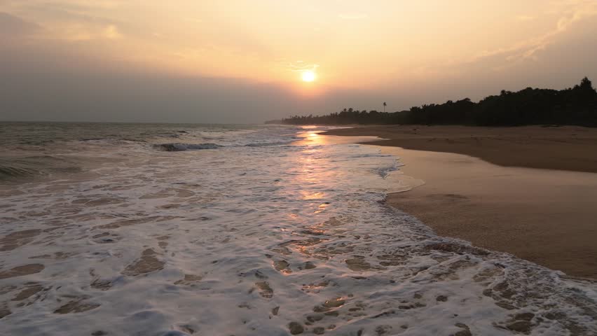 Fly low over Quiet beach in Sri Lanka during golden sunset 1of2