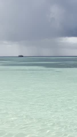 Paradise beach in the Maldives on a sunny day. Crystal clear water and palm tree lined sandy beaches