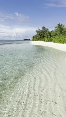 Paradise beach in the Maldives on a sunny day. Crystal clear water and palm tree lined sandy beaches
