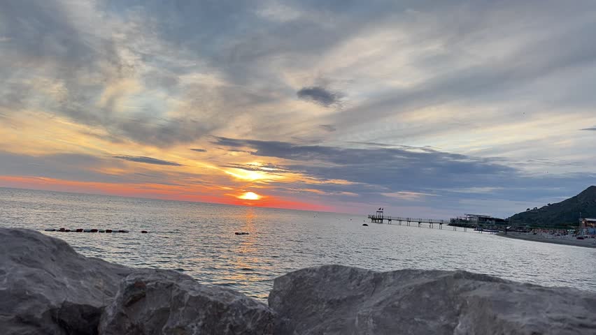 Vibrant sunset timelapse over the Adriatic Sea in Durrës, Albania, featuring dramatic moving clouds and a coastal pier
