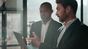 Two diverse men multiracial businessmen business team online presentation with laptop in sunny office teamwork working Caucasian businessman presenting digital data African American leader listening - Powered by Shutterstock - Get 15% off with code: PIKWIZARD15