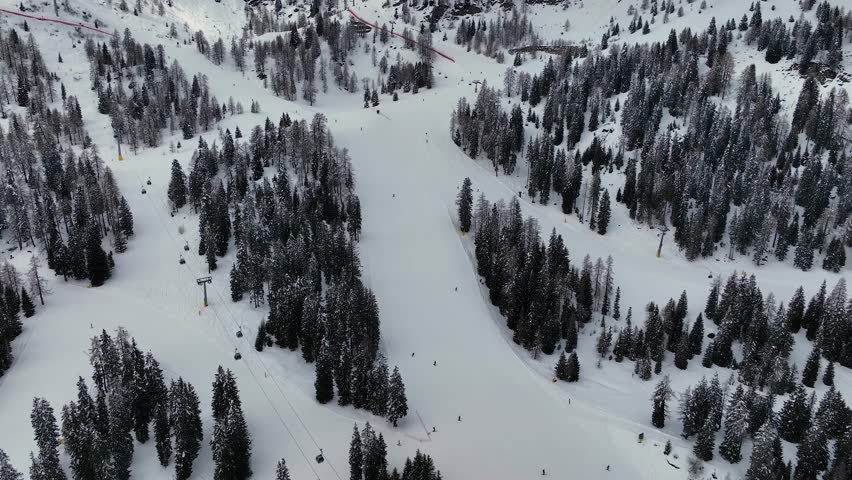 Aerial view of ski resort Madonna di Campiglio in winter with snowy mountain forest, chair lift at ski resort. Winter landscape scene with snow covered trees. Italian Alps from above, Italy, Europe